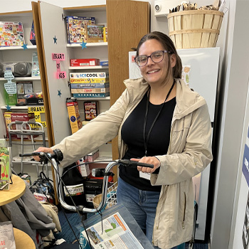 justice holds a bike up in a classroom